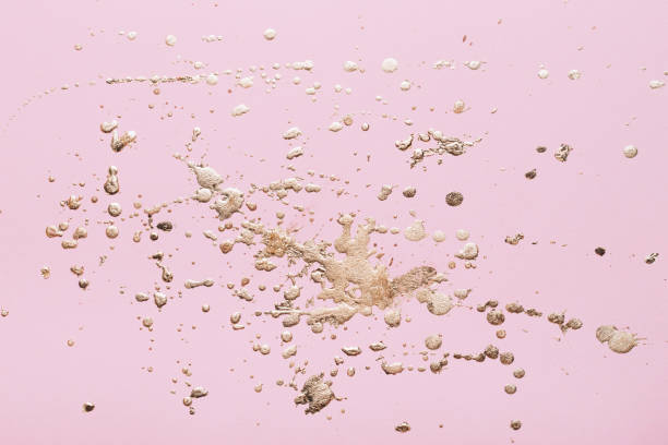 istock Gold potal drops and splashes on pale pink paper. Creative background 1252582769