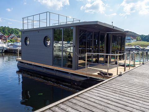 in a harbour two houseboats are moored side by side on a jetty