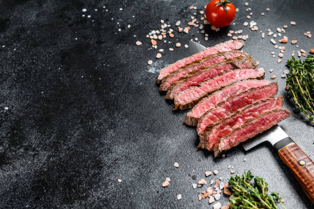 구운 슬라이스 플랫 아이언 희귀 스테이크. 대리석 쇠고기 고기. 검은 색 배경. 맨 위 보기입니다. 복사 공간 - steak close up grilled skirt steak 뉴스 사진 이미지