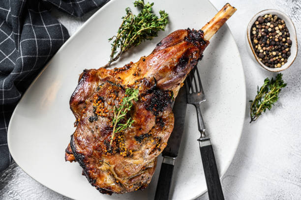 istock BBQ lamb leg with herbs. Gray background. Top view 1252586745