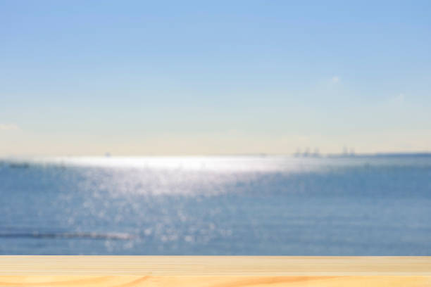 istock Blank wood table top against blurred shining sea 1252587664