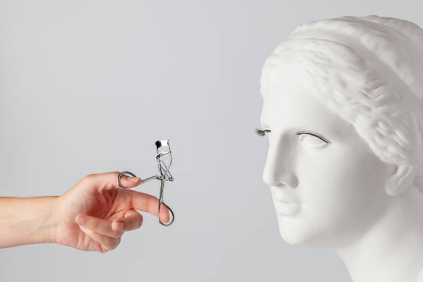 Beauty concept. Aphrodite's plaster bust with artificial lashes. Eyelash curler in hand lash and brow comb stock pictures, royalty-free photos & images