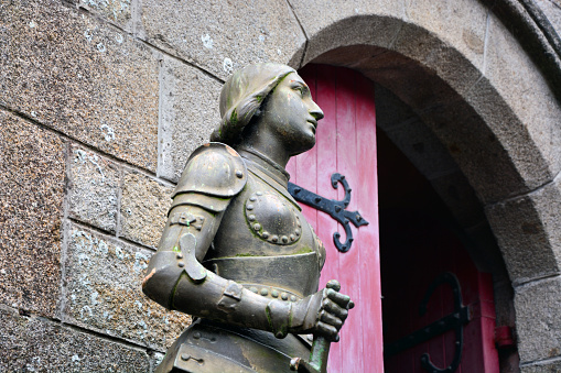 Statue of Joan of Arc (1908) by Maison Raffl in the abbey of Mont Saint Michel, Normandy, France. Composite photo