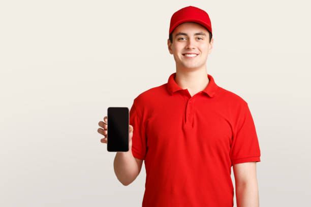 istock Application for delivery. Courier holding smartphone with blank screen 1252605557