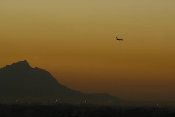 A silhouette of a airplane flying over Table Mountain stock photo