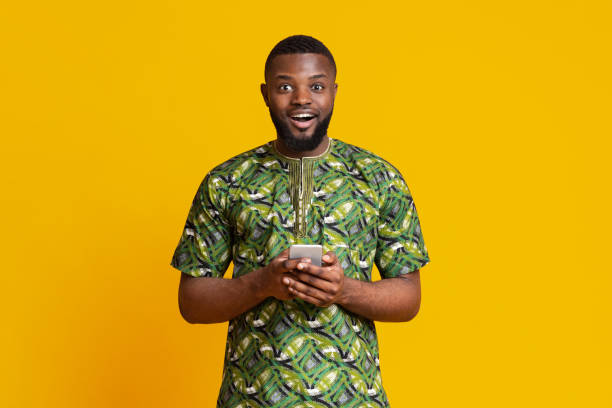istock Excited black guy holding modern mobile phone 1252607697