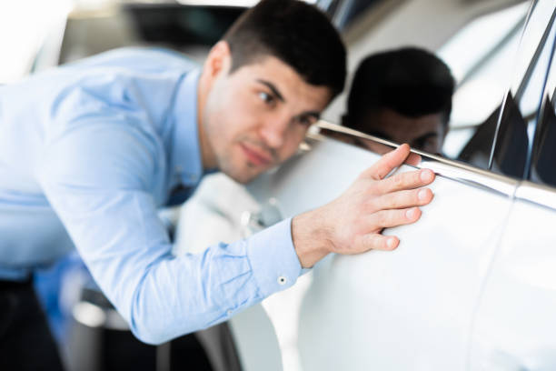 istock Guy Touching His New Auto In Dealership Showroom 1252607737