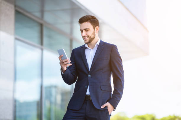 istock Successful young enterpreneur using cellphone for online communication near government office 1252607840