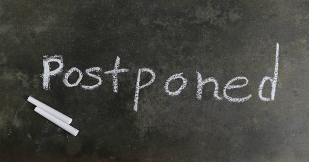 istock Postponed Word Written on Blackboard with White Chalk 1252610248