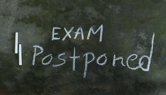 Examen pospuesto escrito en Blackboard con tiza blanca photo