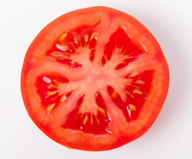 istock Slice of fresh tomato closeup, isolated on white, 1252613513