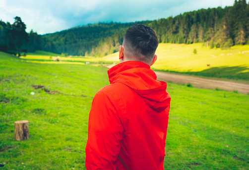 Man in red raincoat in the forest