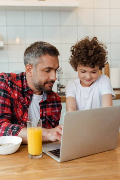 istock selective focus of handsome freelancer father and curly son using laptop in kitchen 1252615833