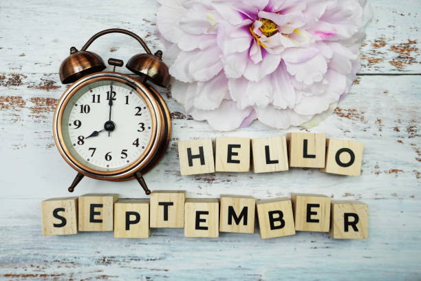 istock Hello September with alarm clock on wooden background 1252616048