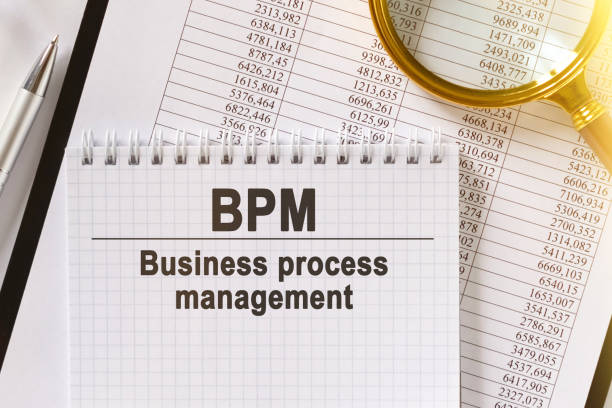 istock On the table are financial reports, a pen, a magnifying glass and a notebook with the inscription - BPM. 1252616077