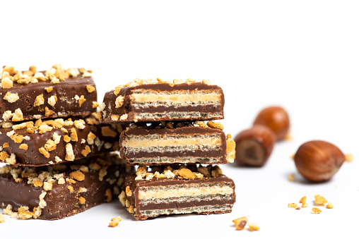 Chocolate biscuit dessert sprinkled with hazelnuts isolated on white background