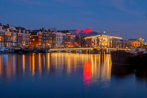 Photo of City scenic from Amsterdam at the river Amstel with the Tiny bridge in the Netherlands at night