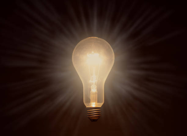 istock glowing light bulb against dark background, drawn stripes as rays of light 1252617437