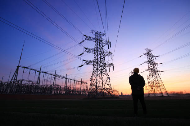 de arbeiders van de elektriciteit en pyloonsilhouet - energiecentrale stockfoto's en -beelden