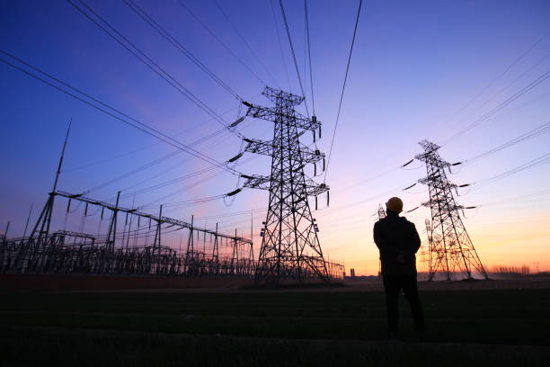 Electricity workers and pylon silhouette Electricity workers and pylon silhouette power plant workers stock pictures, royalty-free photos & images