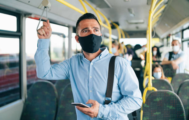 istock Worried men with protective face mask using smart phone in the bus,during COVID-19 1252621931