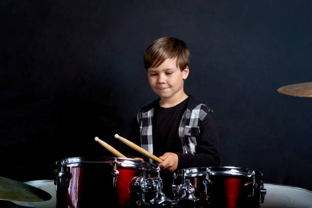 istock Beautiful brunette boy learning to play the drums in the studio. 1252624528