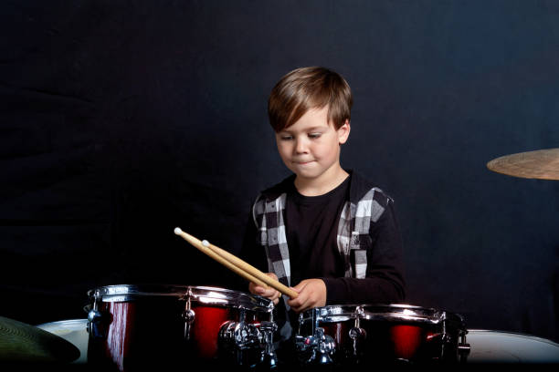 istock A brunette child is sitting with drumsticks in his hands. Studying in the studio 1252624603