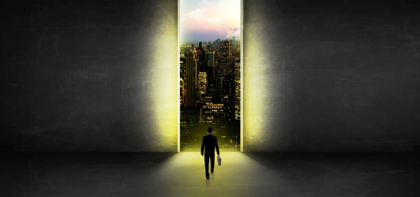 istock Businessman looking to a cityscape from a dark empty room 1252627557