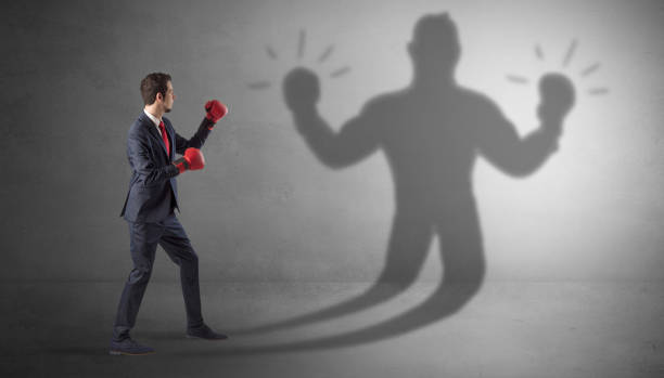 istock Businessman fighting with his unarmed shadow 1252627801