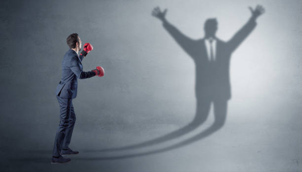 istock Businessman fighting with a disarmed businessman shadow 1252628312