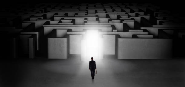 istock Lost businessman standing at illuminated labyrinth entrance 1252639564