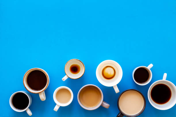 istock Cups of hot drinks on blue background from above frame copy space 1252644047