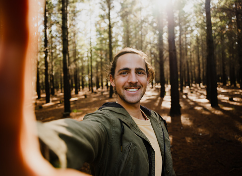 Self portrait of young happy caucasian male in the woods, close-up selfie. High quality photo