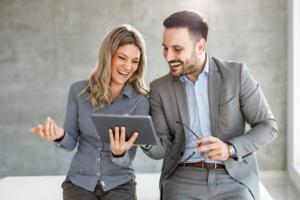 istock Happy business couple reading an e-mail on touchpad in the office. 1252655612