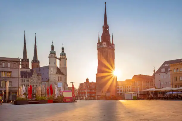 Cityscape image of historical downtown of Halle (Saale) with the Red Tower and the Market Place during beautiful summer sunset.