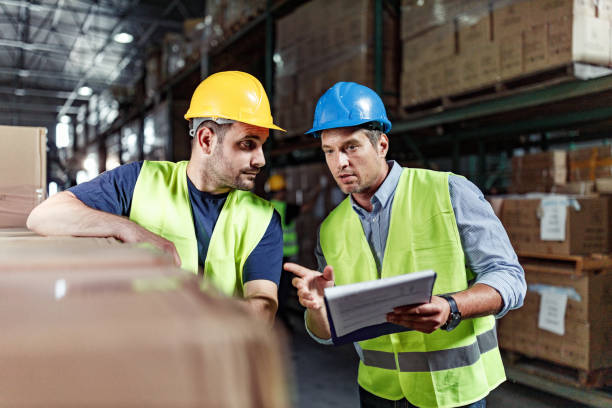 istock Manager giving instructions to his worker in distribution warehouse. 1252665777