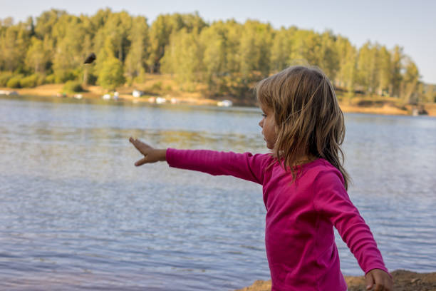 menina no lago - throwing stone human hand rock - fotografias e filmes do acervo