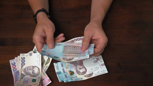 男は新しいウクライナの紙幣を考慮します。●男の手は、紙幣の額面1000グリブナのパックを保持しています。クローズアップショット - human hand beak currency stack ストックフォトと画像