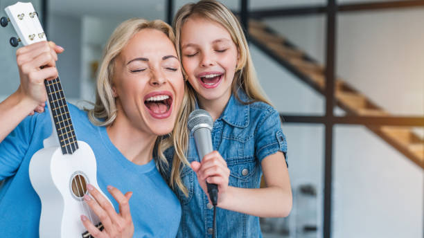 Caucasian mother with little girl singing in karaoke at home Child, People, Females, Parent, Happiness karaoke photos stock pictures, royalty-free photos & images