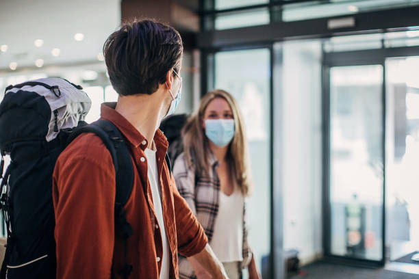 istock Couple with protective face masks entering the hotel lobby 1252674861