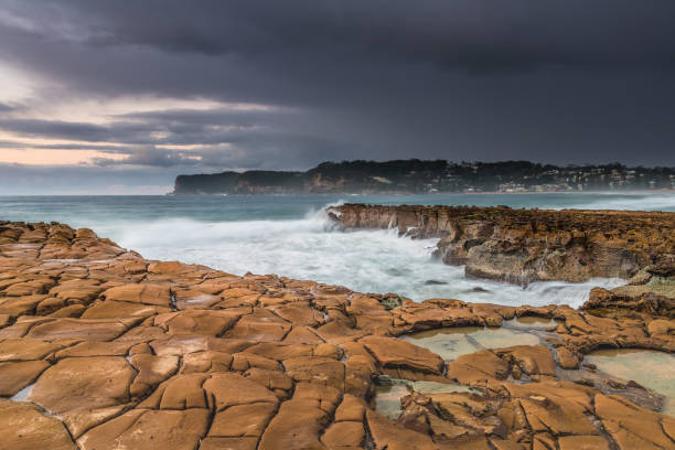 istock Rain Clouds and a Rocky Sunrise Seascape with Cascades 1252677401