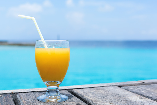 Fresh fruity welcome drink on tropical vacation with sea background and copy space,