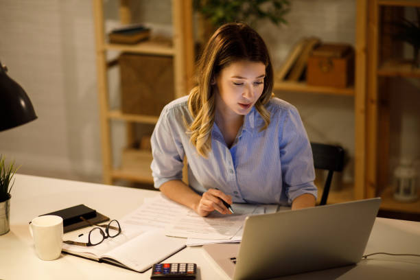 istock Young woman doing finances at home using laptop 1252677470