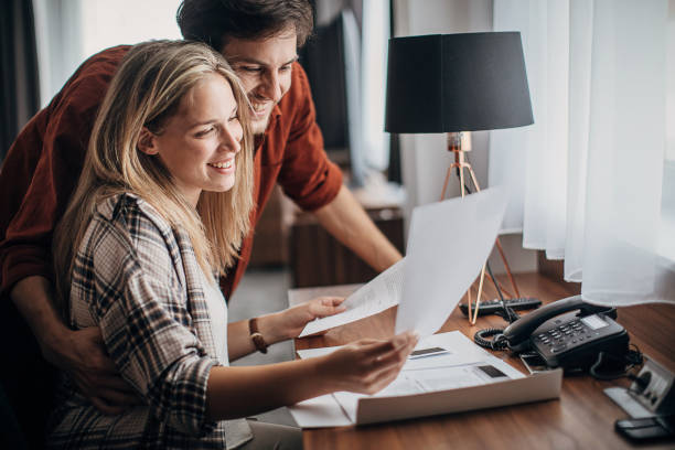 istock Beautiful young couple reading a guide in a hotel room 1252677549