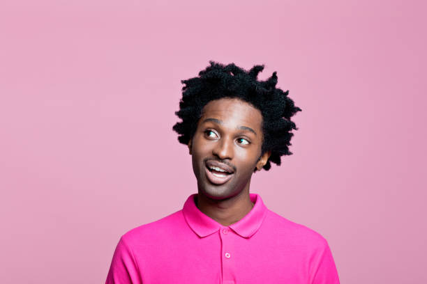 headshot de jovem surpreso vestindo camisa polo rosa - polo shirt african ethnicity men african descent - fotografias e filmes do acervo