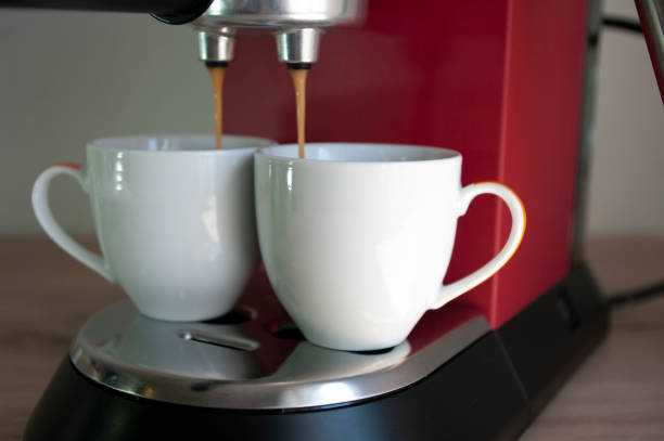 istock Two cups of espresso, preparing coffee process, red coffee machine. 1252680363
