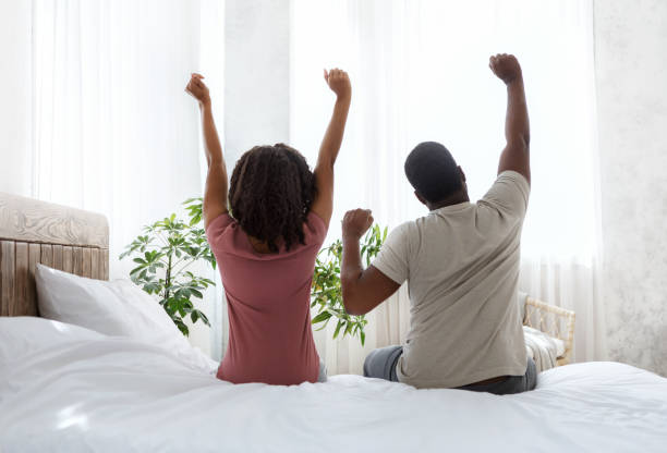 vista trasera de la pareja casada que se extiende en el dormitorio después de la atención - stretching boyfriend indoors lifestyles fotografías e imágenes de stock