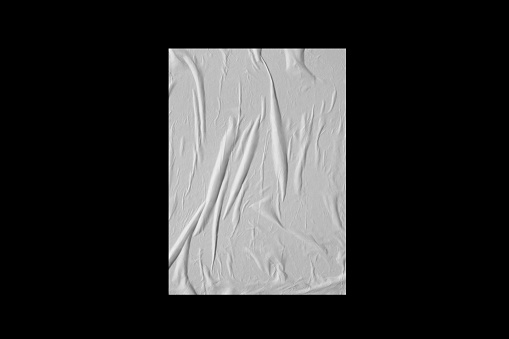 Sheet of white crumpled paper isolated on a black background.