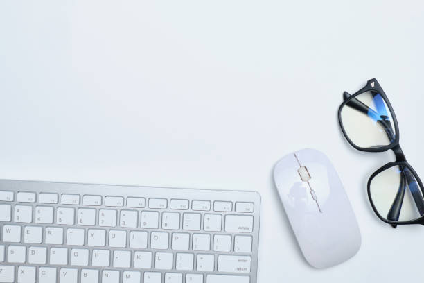 istock Workplace with keyboard, mouse and glasses on a white table with copy space and top view. 1252682686