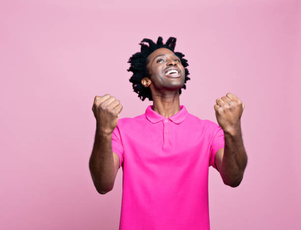 jovem de sucesso vestindo camisa polo rosa - polo shirt african ethnicity men african descent - fotografias e filmes do acervo